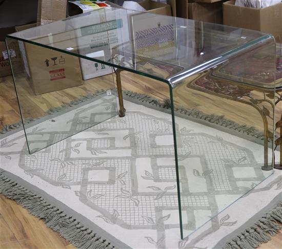 A curved glass table w.127cm.